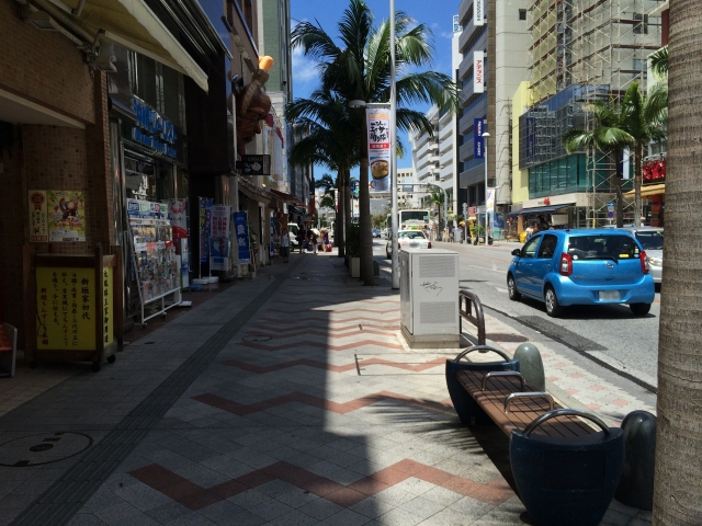 昼の晴れた沖縄国際通り商店街の歩道