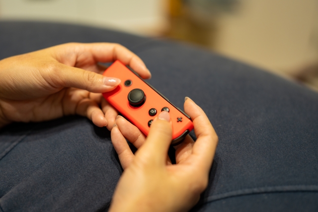 任天堂スイッチのコントローラを持つ手